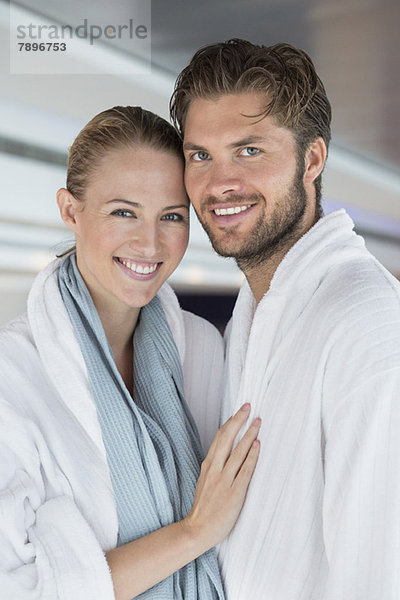 Porträt eines lächelnden Paares im Bademantel im Spa
