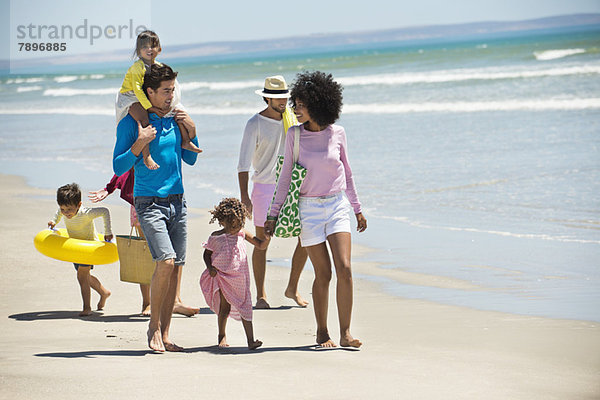 Familien  die am Strand spazieren gehen