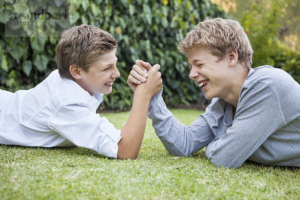 Zwei Jungen Armdrücken auf Gras