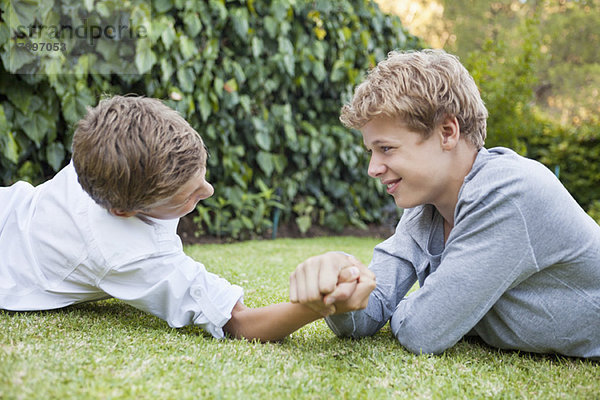 Zwei Jungen Armdrücken auf Gras