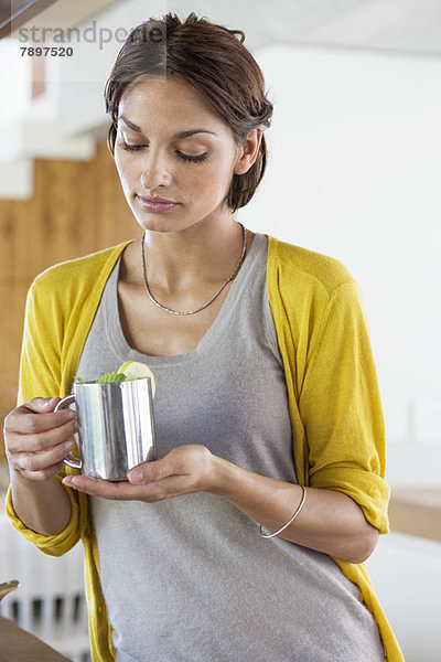 Frau mit einer Tasse Kräutertee in der Küche