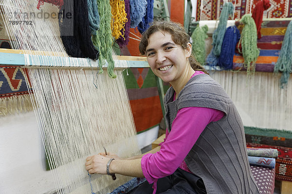 Frau arbeitet in der Teppichknüpferei Desen Halicilik