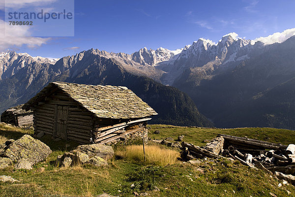Alte Holzhütte mit Schieferdach  hinten die Gipfeln der Badile-Gruppe