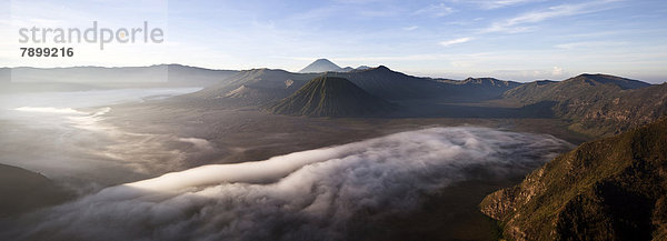 Morgennebel in der Tengger-Caldera mit dem Vulkan Bromo  Krater Mitte links  Vulkan Batok  Mitte  hinten Vulkan Semeru