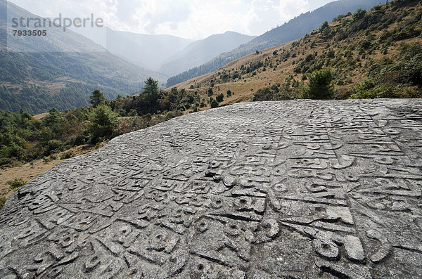 'Das Sanskrit-Mantra ''Om Mani Padme Hum'' in großen Fels gehauen  Berge hinten'