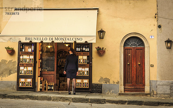 Frau blickt in einen Weinladen von Brunello di Montalcino hinein