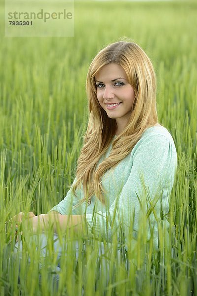 Blonde junge Frau in einem Kornfeld