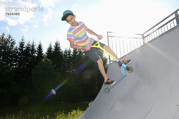 Junge mit Kickboard in einem Skatepark