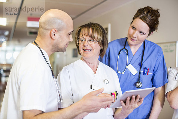 Oberärztin diskutiert mit Kollegen im Krankenhaus über digitale Tabletten