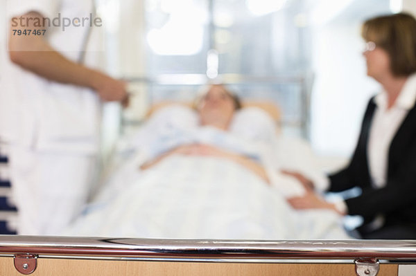 Patientin mit Arzt und Mutter im Krankenhaus mit Schwerpunkt Stab