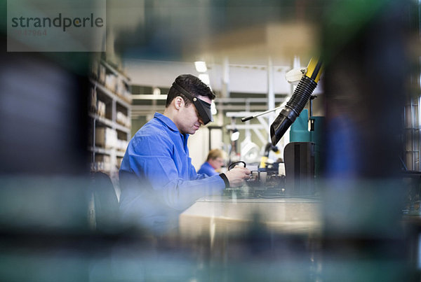 Seitenansicht des in der Industrie tätigen Technikers mit Schutzbrille