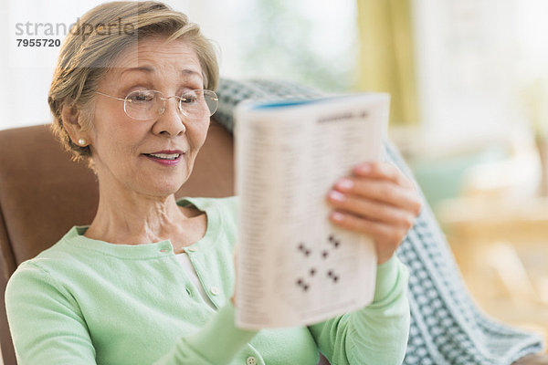 Senior Frau macht Kreuzworträtsel