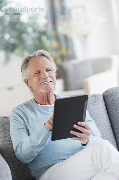 sitzend  Senior  Senioren  Mann  Couch  Tablet PC