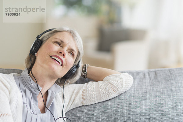 sitzend  Senior  Senioren  Frau  zuhören  Couch  Musik