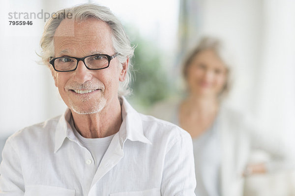 Portrait of senior man  woman in background