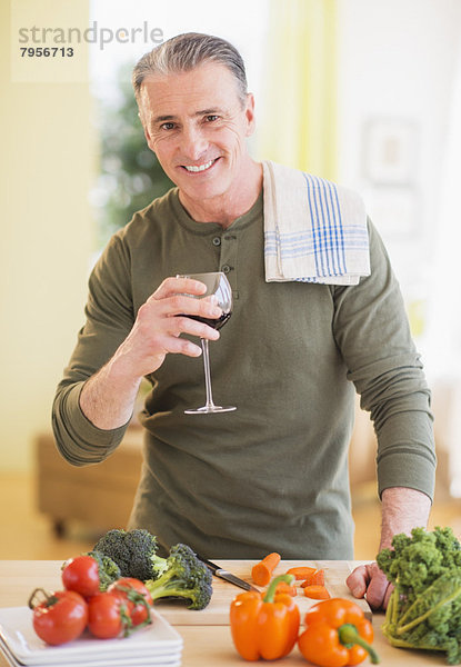 Portrait of man in kitchen  holding wine glass