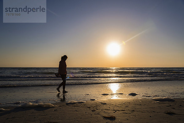 USA  Florida  Indian Rocks Beach  Reife Frau am Strand bei Sonnenuntergang