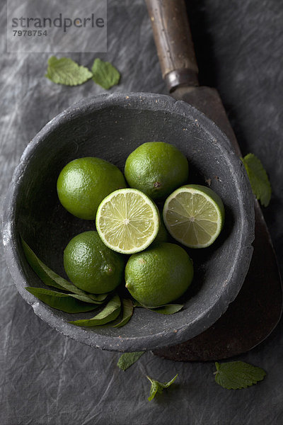 Bowl of lime with sickle on black textile  close up