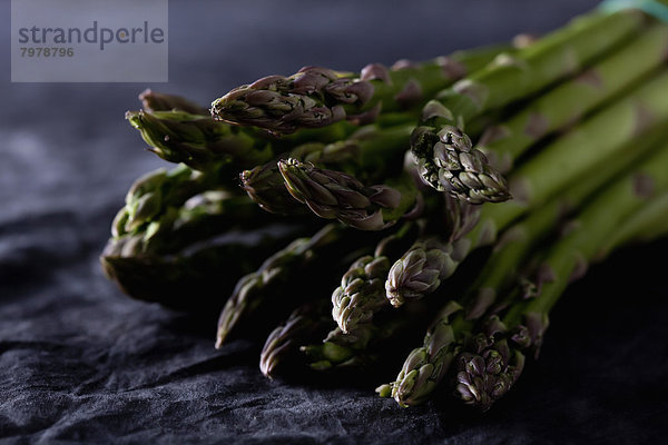 Bunch of green asparagus on textile  close up