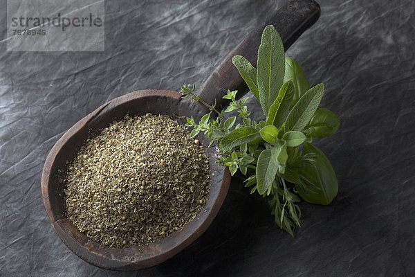 Variety of Italian herbs and powder in wooden spoon  close up
