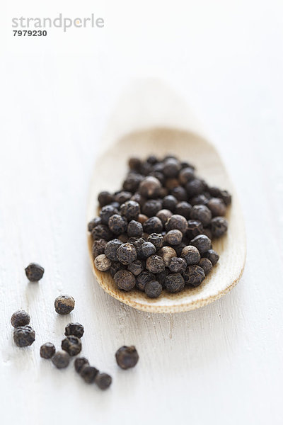 Black peppercorn on wooden spoon  close up