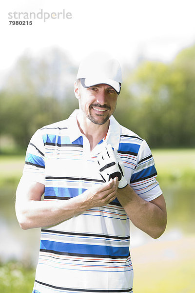 Porträt eines Mannes auf dem Golfplatz  lächelnd