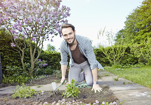 Porträt eines jungen Mannes im Garten  lächelnd