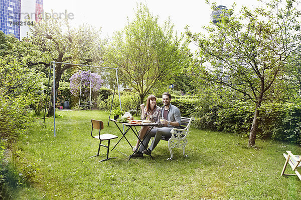 Deutschland  Köln  Junges Paar beim Frühstück im Garten