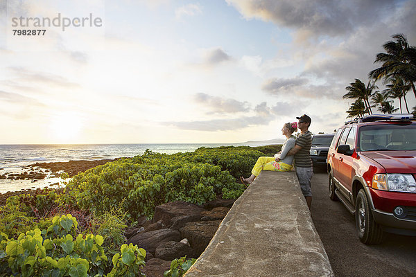 USA  Hawaii  Mittleres erwachsenes Paar bei Sonnenuntergang am Strand