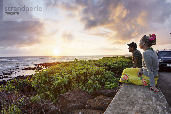 USA  Hawaii  Mittleres erwachsenes Paar bei Sonnenuntergang auf dem Meer
