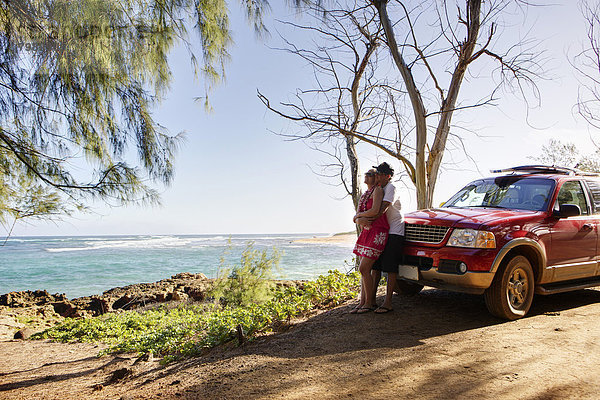 USA  Hawaii  Mittleres erwachsenes Paar in der Nähe eines Autos
