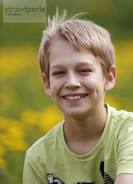 Deutschland  Baden Württemberg  Portrait des Jungen auf der Wiese  lächelnd