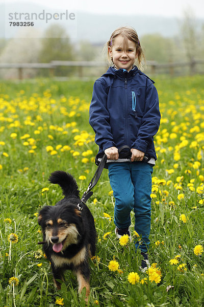 Deutschland  Baden Württemberg  Porträt eines Mädchens mit Hund auf der Wiese