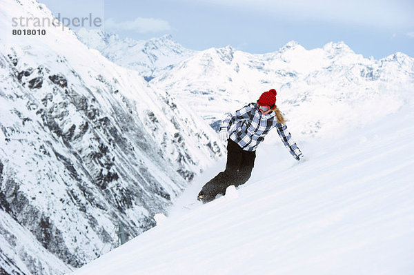 Junge Frau beim Snowboarden