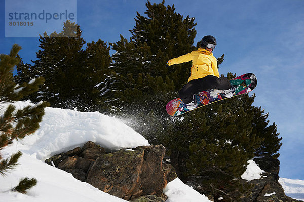 Junge Snowboarderin beim Springen