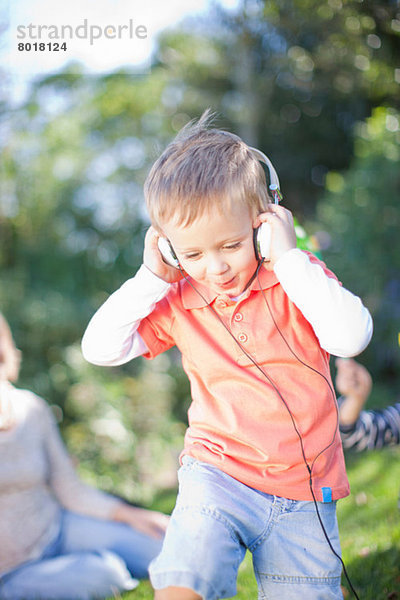 Junge hört Musik im Freien