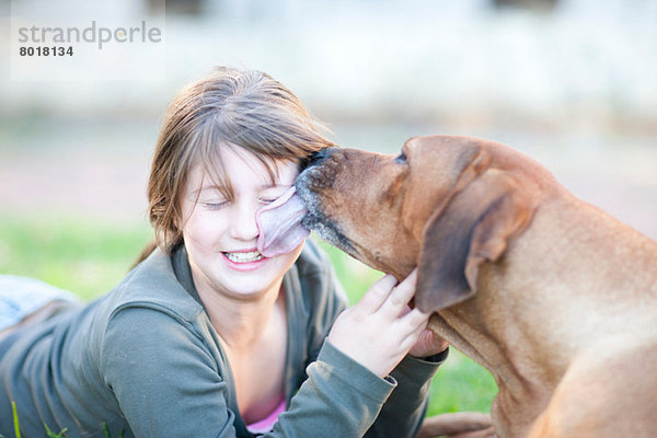 Hund leckt Mädchengesicht