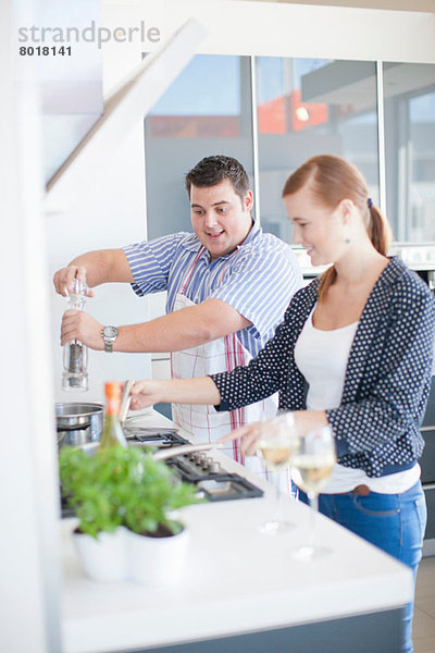 Junger Mann und Frau beim Kochen in der Küche