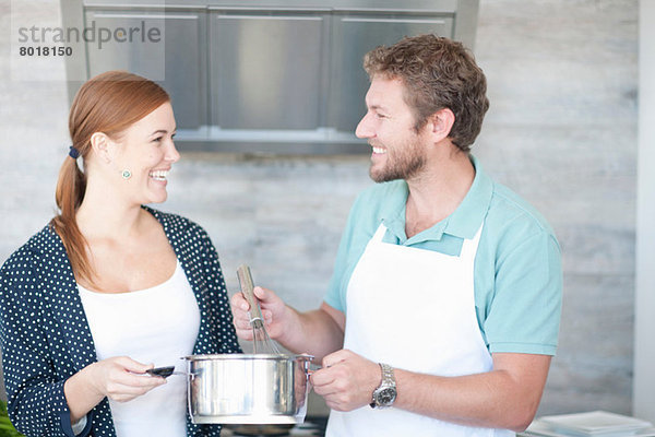 Junger Mann und Frau beim Kochen in der Küche