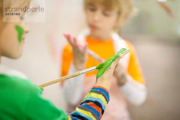 Jungen bemalen ihre Hände