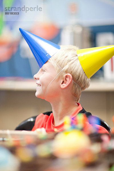Junge auf Geburtstagsfeier mit zwei Partyhüten