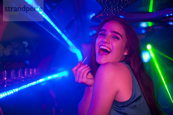 Junge Frau lacht an der Bar im Nachtclub  Mund