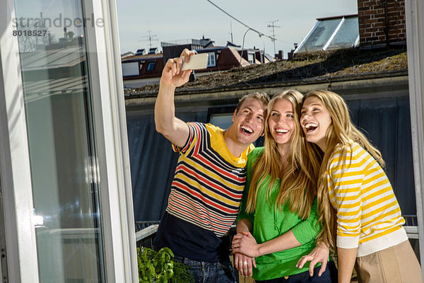 Drei junge Freunde  die sich auf dem Dach fotografieren.