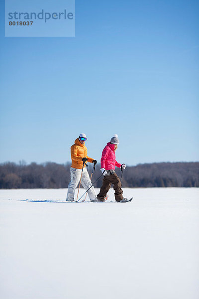 Erwachsenes Paar  das auf Schnee läuft