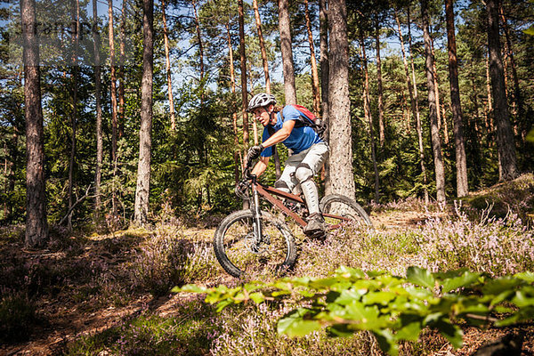 Mann mit dem Mountainbike durch den Wald