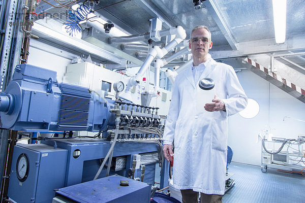 Portrait eines Laboranten  der ein leeres Glas hält