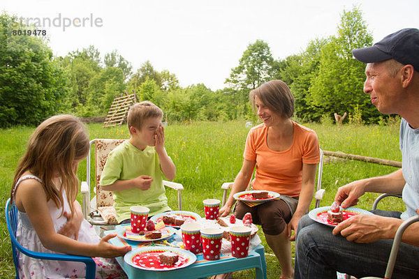 Familie mit zwei Kindern beim Geburtstagspicknick