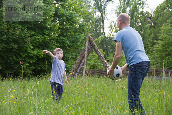 Vater und Sohn spielen mit dem Fußball