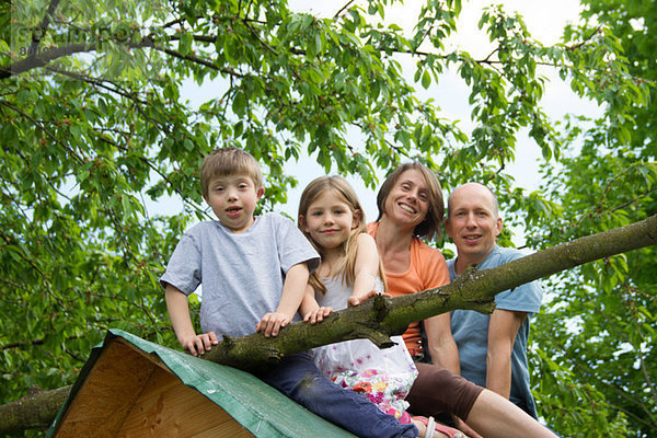 Familie mit zwei Kindern auf dem Spielhausdach