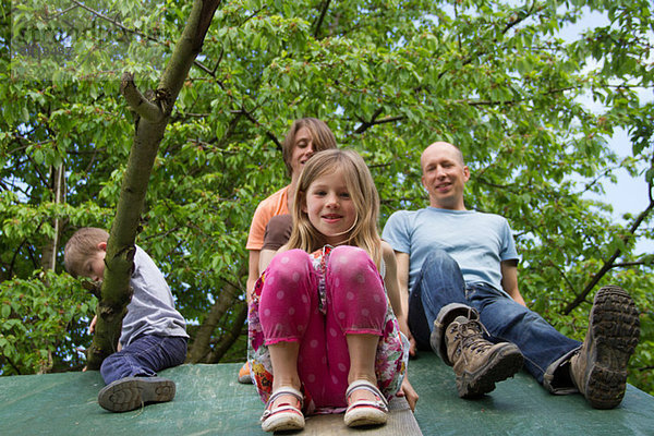 Familie mit zwei Kindern auf dem Spielhausdach